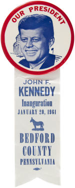STRIKING "OUR PRESIDENT" JFK PORTRAIT BUTTON WITH ATTACHED INAUGURAL RIBBON.